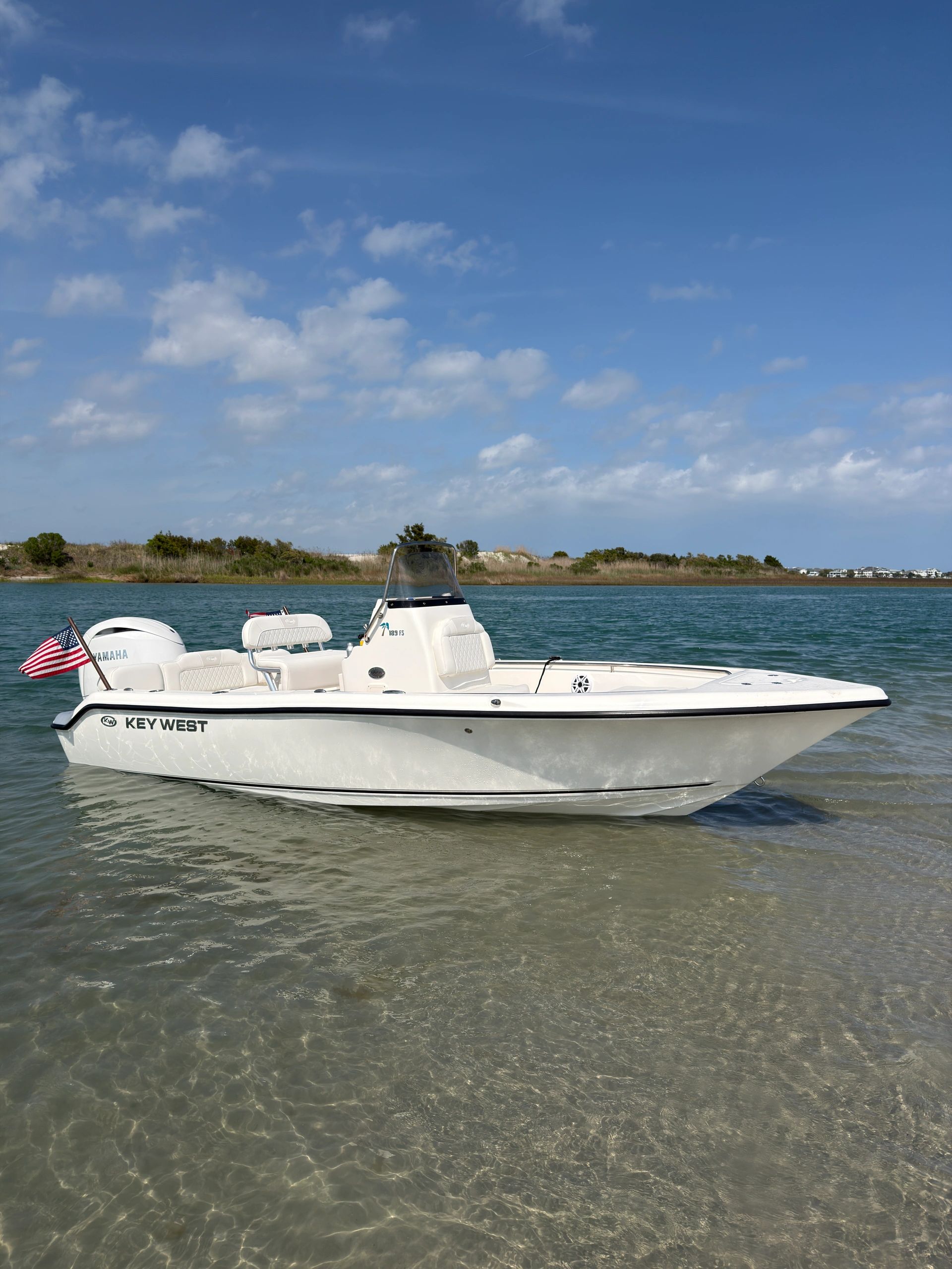 White fishing boat anchored sandbar