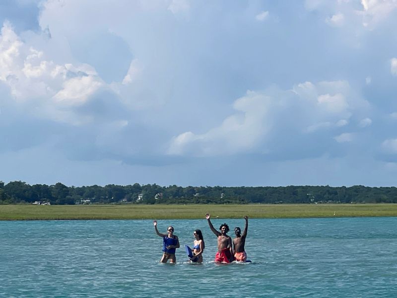 People wading in water arms raised